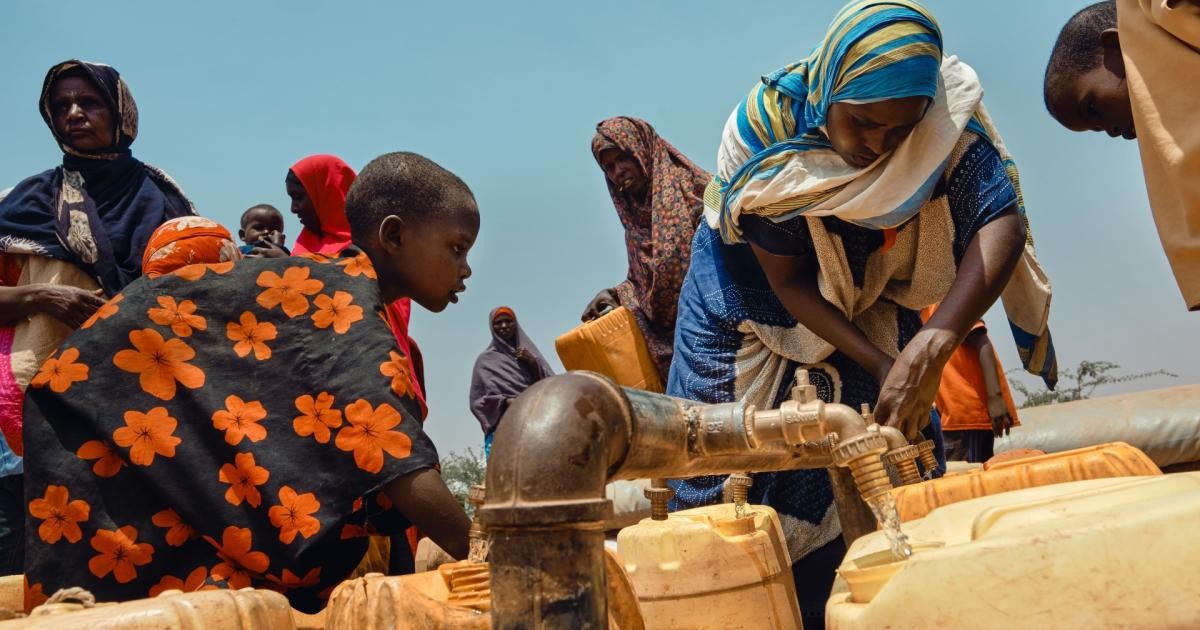 Women and children collecting water at a community water point