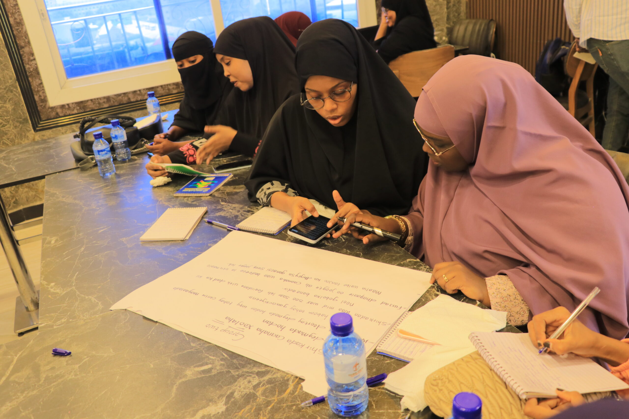 Women taking notes during a HURDO group discussion